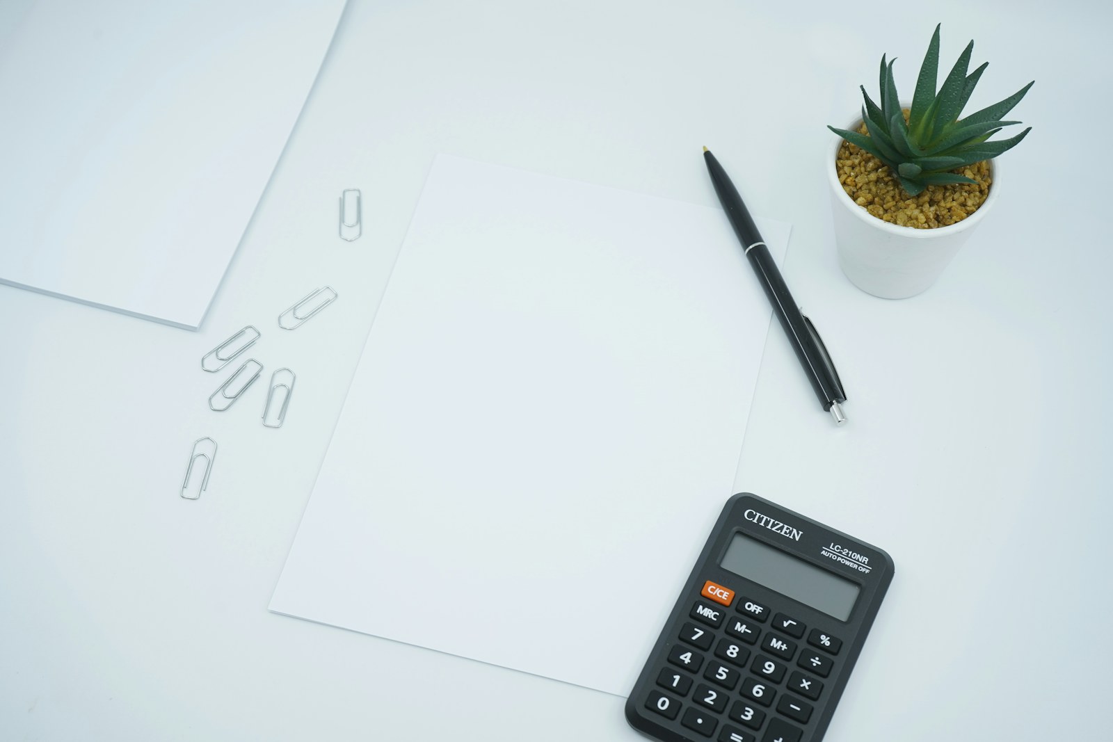 A calculator and documents on a desk for cost estimating.