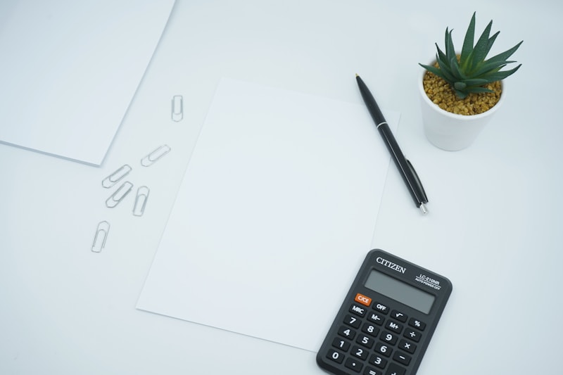 A calculator and documents on a desk for cost estimating.