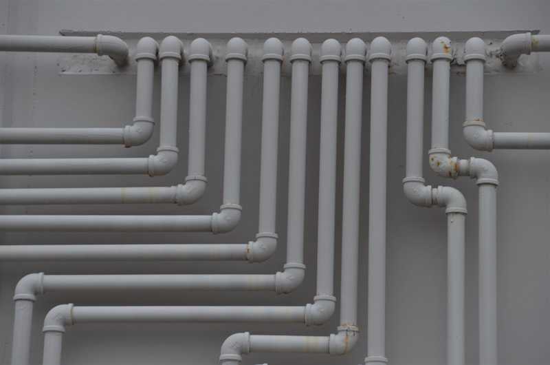 Plumbing pipework running along a wall.