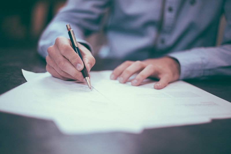 A contract being signed with a pen.